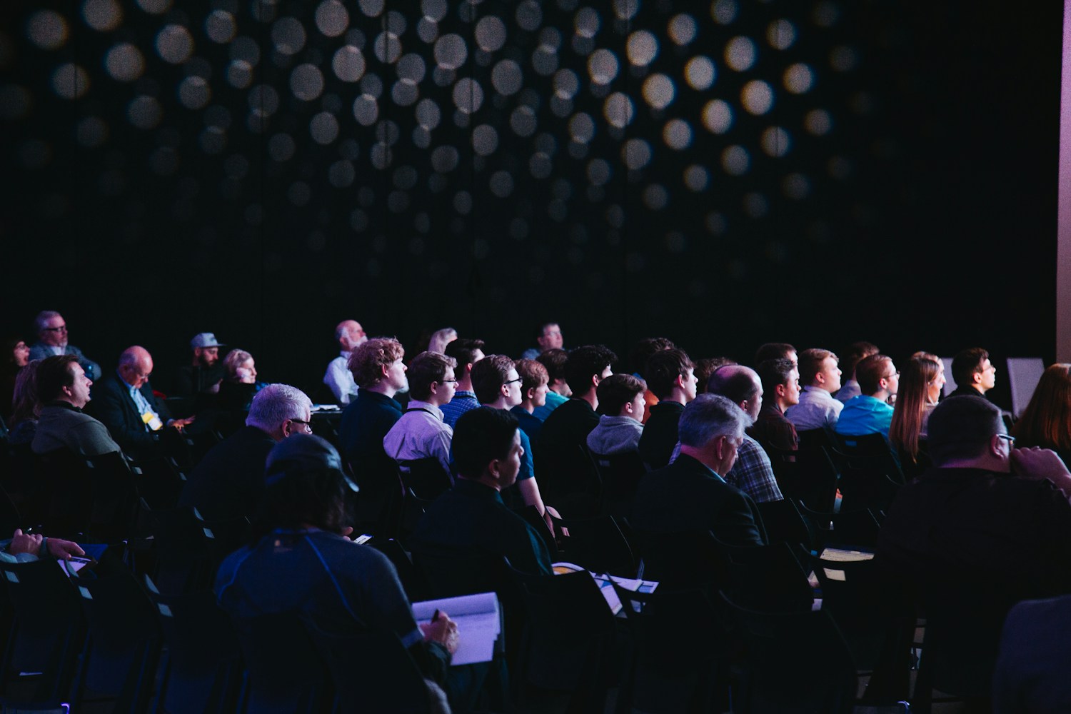 People gathered at a conference, listening to a speaker